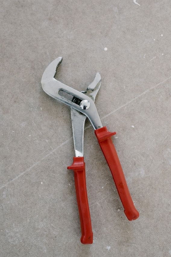 Pliers with red handles on concrete flooring