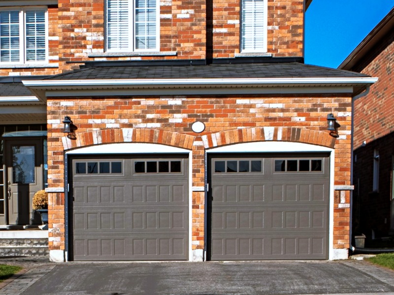 Brick house with short panel doors on two-car garage