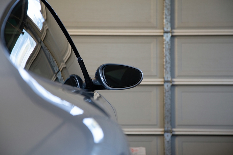 Silver sedan facing closed garage door inside of garage